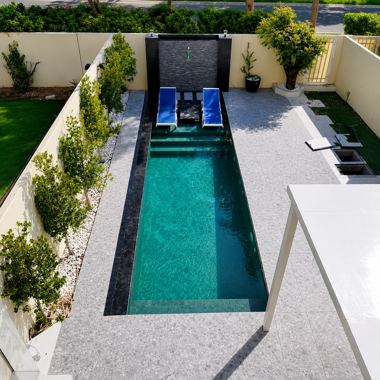 Villa pool construction Dubai with modern house design, pergola, and clear water pool