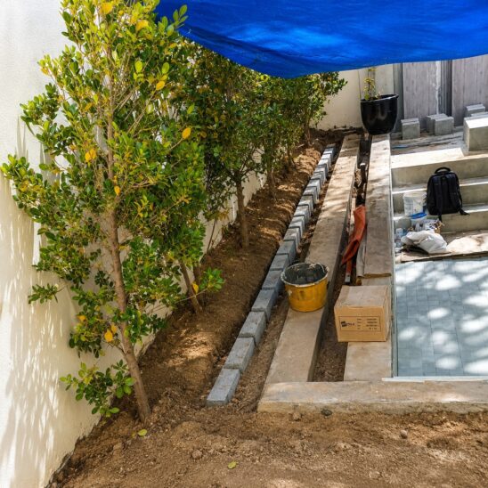 Swimming pool and landscaping companies in Dubai completing villa landscaping with edging and patio construction